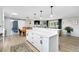 Bright, open kitchen with white cabinetry, large island, and adjacent dining area at 6439 E Maplewood Ave, Centennial, CO 80111