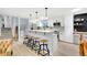 Bright kitchen boasts white cabinetry, stainless appliances, a breakfast bar, and modern pendant lighting at 6439 E Maplewood Ave, Centennial, CO 80111