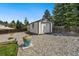 A backyard storage shed with a garage door and an adjacent flower pot, offering space for storage and hobbies at 6439 E Maplewood Ave, Centennial, CO 80111