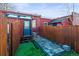 Backyard area with artificial grass and tiled patio leading to the back entrance of the home at 1235 31St St, Denver, CO 80205