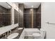 Modern bathroom featuring dark tiles, double sinks with granite countertop and a tub with shower at 1235 31St St, Denver, CO 80205