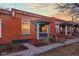 Quaint brick row house featuring well-maintained landscaping and a covered porch entry at 1235 31St St, Denver, CO 80205