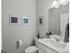 Powder room featuring modern fixtures, neutral colors, and framed artwork at 8346 E 132Nd Dr, Thornton, CO 80602