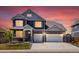 Charming two-story home at twilight, featuring stone accents, a two-car garage, and a well-manicured lawn at 8346 E 132Nd Dr, Thornton, CO 80602