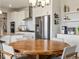 Kitchen and dining area featuring modern appliances, white cabinetry, and a large wooden table with seating at 8346 E 132Nd Dr, Thornton, CO 80602