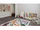 Bright playroom with an animal themed rug, colorful learning materials and a bench with pillows at 8346 E 132Nd Dr, Thornton, CO 80602