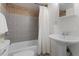Bathroom with a shower-tub combo and white pedestal sink at 3300 Oneida St, Denver, CO 80207