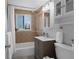 Well-lit bathroom featuring a shower-tub, ceramic tiling, modern vanity, and window for natural light at 3300 Oneida St, Denver, CO 80207