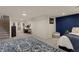Open bedroom area with a comfortable sitting area, desk, and stairs leading to another level at 3300 Oneida St, Denver, CO 80207