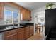 The cozy kitchen features wood cabinets, a stainless steel sink, and granite countertops at 3300 Oneida St, Denver, CO 80207