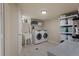 Functional laundry room with new washer and dryer, storage and ample counter space at 3300 Oneida St, Denver, CO 80207