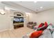 View of the finished basement area with a large TV, plush seating, and neutral carpeting at 7 Sandpiper Cir, Thornton, CO 80241