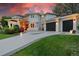 Stunning two-story home featuring a three-car garage and beautifully landscaped front yard at sunset at 7 Sandpiper Cir, Thornton, CO 80241