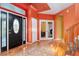 View of the foyer with hardwood floors, staircase, and large front door with decorative glass at 7 Sandpiper Cir, Thornton, CO 80241