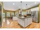 Bright, open kitchen featuring a central island, stainless steel appliances, and hardwood floors at 7 Sandpiper Cir, Thornton, CO 80241