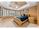 Relaxing primary bedroom featuring tray ceiling, many windows and soft natural light at 7 Sandpiper Cir, Thornton, CO 80241