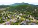 A serene aerial view of a neighborhood nestled among lush green trees and rolling mountains at 3257 Sun Ridge Ln, Evergreen, CO 80439