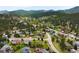 High aerial view showing homes surrounded by green mountains and trees in the neighborhood at 3257 Sun Ridge Ln, Evergreen, CO 80439