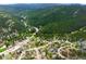 A panoramic view showcasing houses nestled in a lush, green, mountainous neighborhood at 3257 Sun Ridge Ln, Evergreen, CO 80439