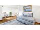 A naturally lit bedroom is nicely decorated with a coastal theme, matching painting, rug and bedding at 3257 Sun Ridge Ln, Evergreen, CO 80439