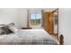 Bright bedroom featuring mountain views, a wooden door and a soft, neutral-toned bedspread at 3257 Sun Ridge Ln, Evergreen, CO 80439