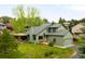 Beautiful exterior of home with green siding, covered porch, manicured lawn and attached garage at 3257 Sun Ridge Ln, Evergreen, CO 80439