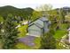 Back exterior of home showcasing an attached garage, green lawn, and access to beautiful mountain views at 3257 Sun Ridge Ln, Evergreen, CO 80439