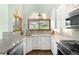 Bright kitchen featuring granite counters, white cabinets, tiled backsplash, and stainless steel appliances at 3257 Sun Ridge Ln, Evergreen, CO 80439