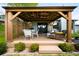 Charming outdoor patio with covered structure, elegant seating, and lush landscaping at 3257 Sun Ridge Ln, Evergreen, CO 80439