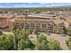 Aerial view of apartment building with balconies, parking garage and lush green neighborhood at 7240 W Custer Ave # 417, Lakewood, CO 80226