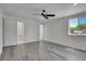 Bedroom with gray wood floors, ceiling fan, and an ensuite bathroom and closet at 5419 E 113Th Ave, Thornton, CO 80233