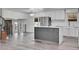 Modern open concept kitchen featuring gray wood floors, white cabinets and stainless steel appliances at 5419 E 113Th Ave, Thornton, CO 80233