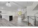 Open-concept layout featuring a kitchen island, living area, and stairs with metal railing at 5419 E 113Th Ave, Thornton, CO 80233
