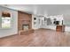 Bright, open-concept living room with modern flooring, brick fireplace, and seamless access to the kitchen at 5419 E 113Th Ave, Thornton, CO 80233