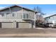 Two-story townhome featuring a private balcony, individual garages, and neutral gray exterior with white trim at 1223 S Wheeling Way, Aurora, CO 80012