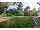 Large backyard with a grassy area and trees providing shade at 7154 S Hudson Cir, Centennial, CO 80122