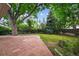 Brick patio in grassy backyard with mature trees at 2957 S York St, Denver, CO 80210