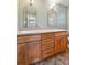 Bathroom vanity boasting double sinks, granite counters, and wood cabinets at 2957 S York St, Denver, CO 80210