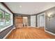 Bright bedroom with hardwood floors, a large window, and a sliding barn door to the bathroom at 2957 S York St, Denver, CO 80210
