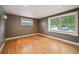 Bedroom featuring hardwood floors and a large window overlooking the neighborhood at 2957 S York St, Denver, CO 80210