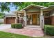 Inviting covered front porch with beautiful wood door, stone walkway, and lush landscaping at 2957 S York St, Denver, CO 80210
