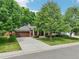 Inviting single-Gathering home featuring a lush front yard, mature trees, and a spacious driveway at 2957 S York St, Denver, CO 80210