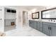 Modern bathroom features double vanity with gray cabinets, marble floors, and access to walk-in closet at 2040 W 45Th Ave, Denver, CO 80211