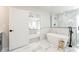 Elegant bathroom features marble tile, soaking tub, glass shower, and open access to bedroom at 2040 W 45Th Ave, Denver, CO 80211