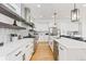 Modern kitchen features an island with seating, white cabinets, and stainless steel appliances at 2040 W 45Th Ave, Denver, CO 80211