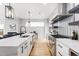 Bright, modern kitchen with an island and stainless steel appliances adjoins the living room at 2040 W 45Th Ave, Denver, CO 80211