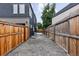 Narrow side yard between the home and a wood fence providing extra outdoor space and privacy at 2040 W 45Th Ave, Denver, CO 80211