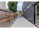Narrow side yard with a concrete walkway and wooden fence, offering privacy and a simple outdoor space at 2040 W 45Th Ave, Denver, CO 80211