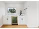 Stylish wet bar features white cabinets, quartz countertop, wine fridge, and sleek black faucet at 2040 W 45Th Ave, Denver, CO 80211
