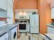 Galley-style kitchen with white cabinetry, built-in microwave and appliances at 9633 Brentwood Way # B, Broomfield, CO 80021